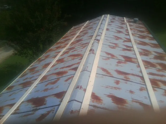 Rusted metal roof panels with new wood purlins before replacement — Storm Damage Roof Repair in Chesapeake City by Roofing Brothers