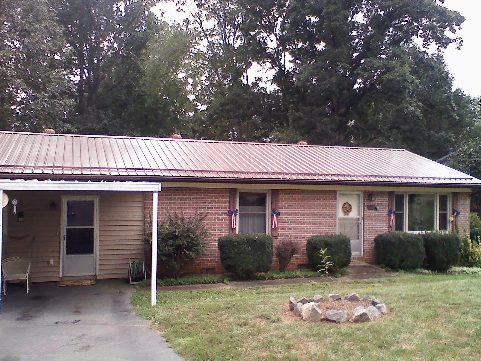 Bronze metal roof and carport on a brick ranch home — Roof Repair work by our crew in Chesapeake City
