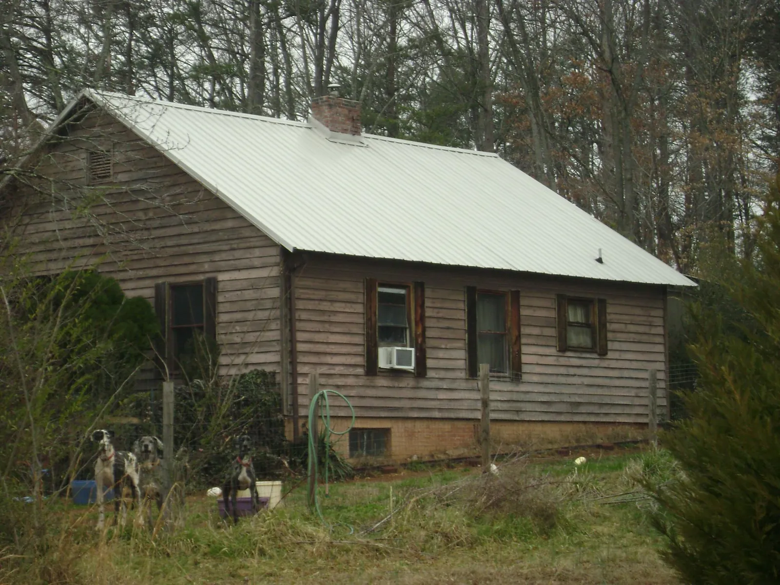 White metal roof on an old wood sided farmhouse, from a Metal Roof Installation job in Chesapeake City